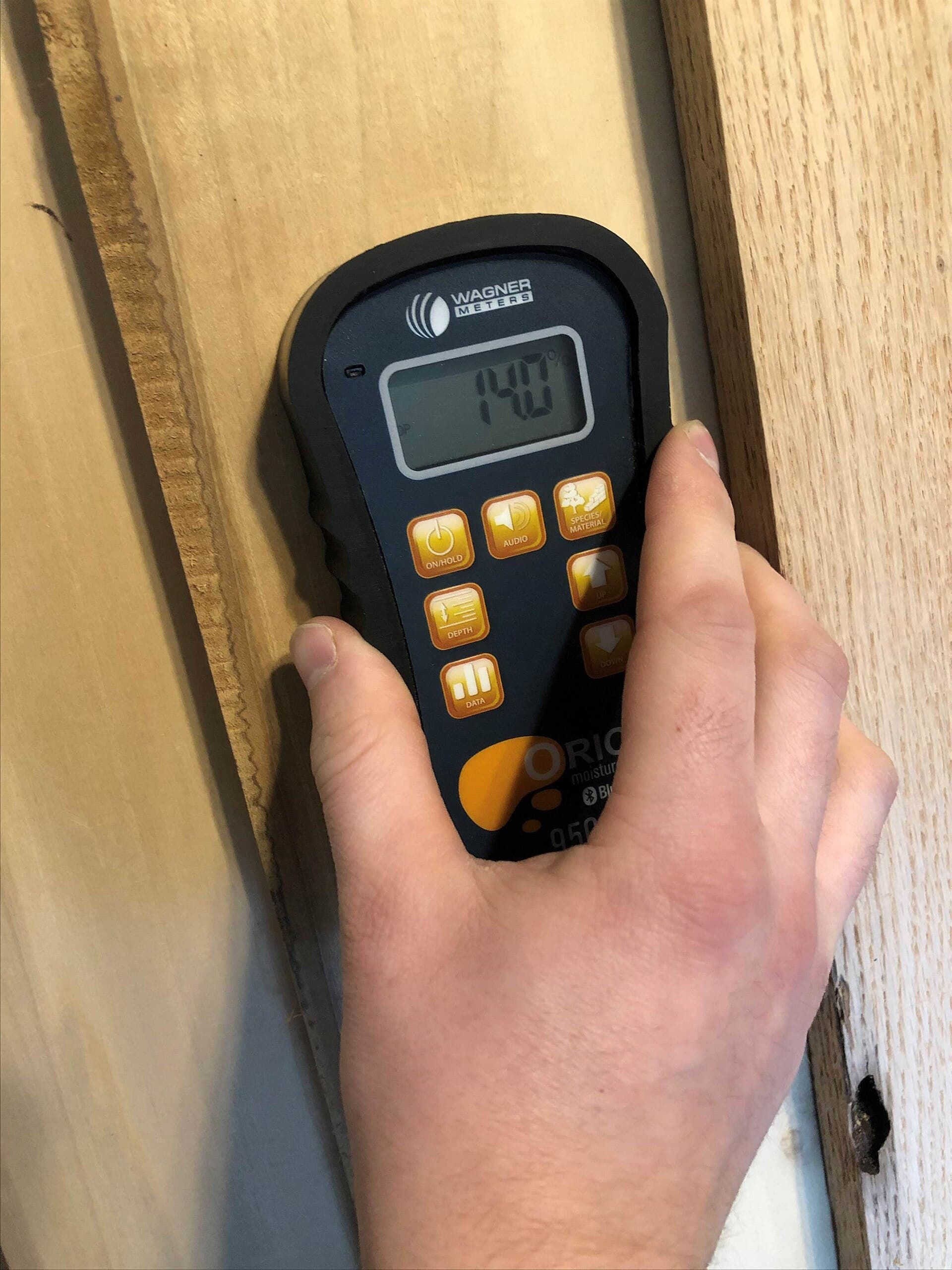Mesure de l'humidité d'une bûche à l'humidimètre à broches, le seul moyen fiable de vérifier qu'un bois est passé sous les 20 % avant de le brûler